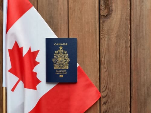 Canadian Passport and flag representing the top 5 immigration pathways in 2025 including Express Entry, PNP, family sponsorship, Study Permit, PGWP, and work permits.