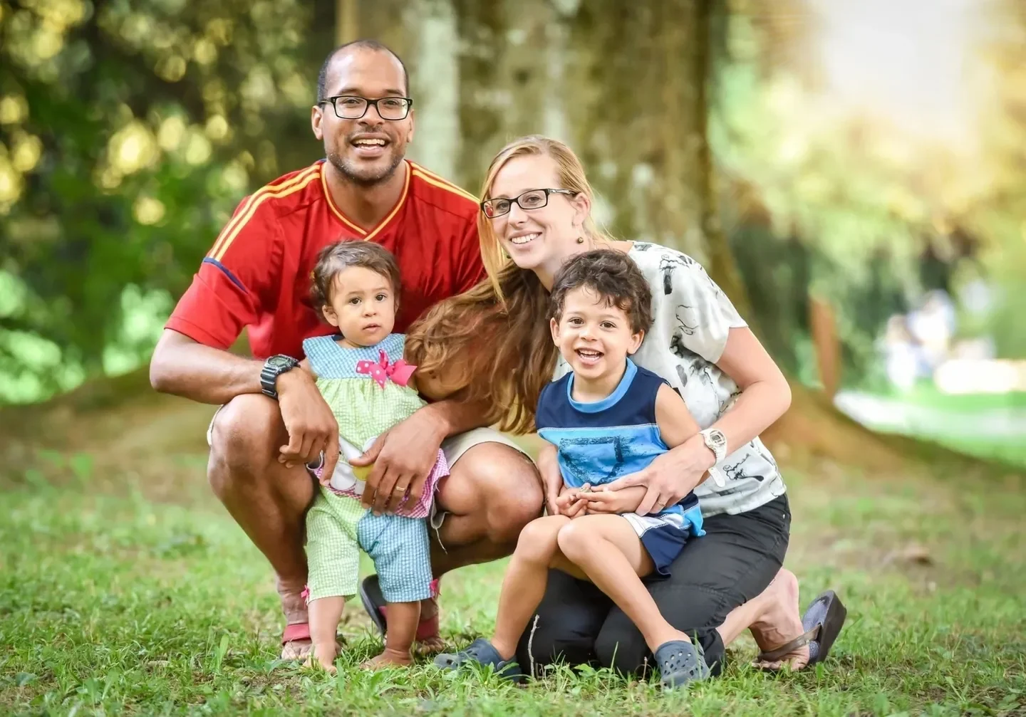 A family posing for the camera in front of some trees