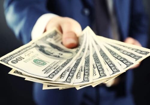 A person holding money in their hand